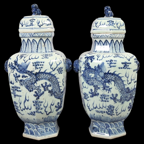 147 - A large pair of Chinese blue and white ceramic dragon decorated jars and covers, height 65cm