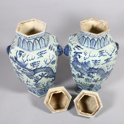 147 - A large pair of Chinese blue and white ceramic dragon decorated jars and covers, height 65cm