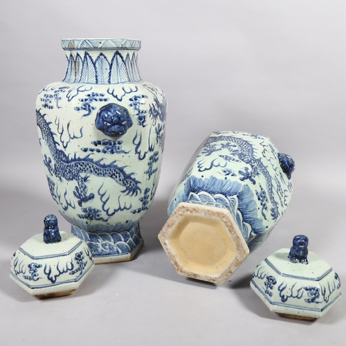 147 - A large pair of Chinese blue and white ceramic dragon decorated jars and covers, height 65cm