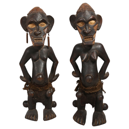 151 - A pair of Congo Tribal carved wood standing figures, height 67cm