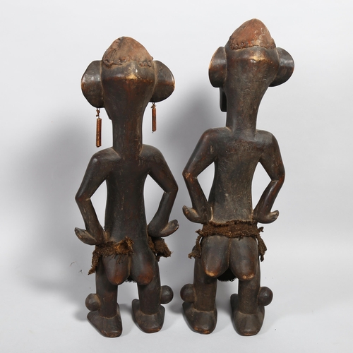 151 - A pair of Congo Tribal carved wood standing figures, height 67cm