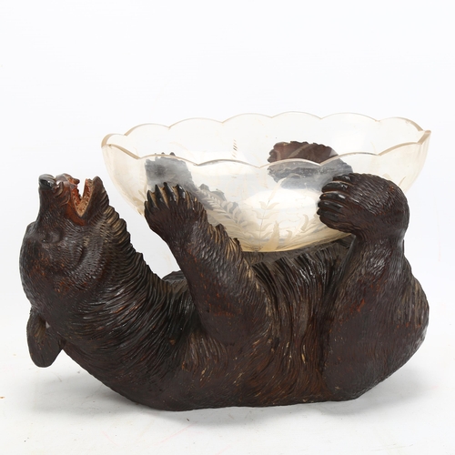 48 - 19th century Black Forest carved and stained wood bear supporting a cut-glass bowl, length 30cm