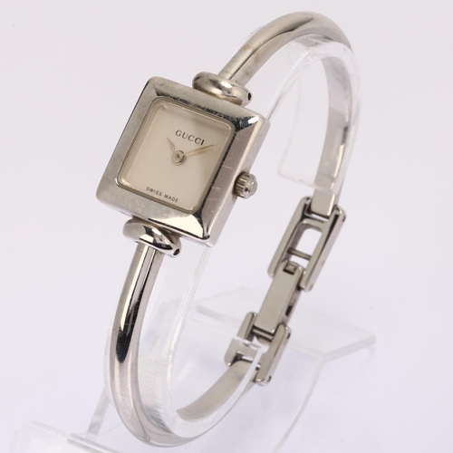 1029 - GUCCI - a lady's stainless steel 19L quartz bangle watch, circa 2000, square silvered dial with leaf... 