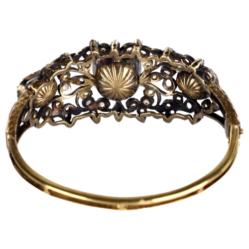 1106 - A fine Victorian emerald and diamond hinged bangle, unmarked gold and silver-topped openwork setting... 