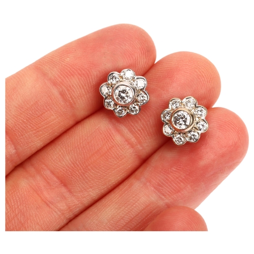 1119 - A pair of diamond flowerhead cluster earrings, unmarked 18ct white gold settings with modern round b... 