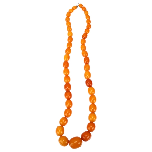 1127 - A single-strand graduated butterscotch amber bead necklace, bead lengths ranging from 25.8 - 11.5mm,... 