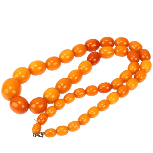 1127 - A single-strand graduated butterscotch amber bead necklace, bead lengths ranging from 25.8 - 11.5mm,... 