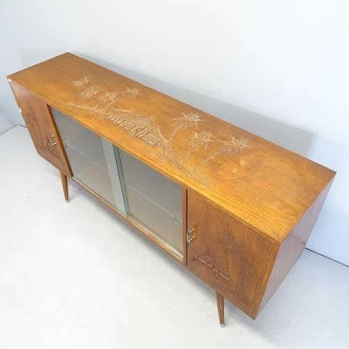 2624 - A Japanese elm sideboard, with two glass sliding doors between two cupboards, carved decoration and ... 