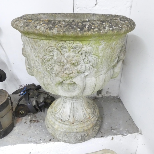 2670 - A weathered concrete two-section garden urn, with lion mask decoration. 56x65cm.