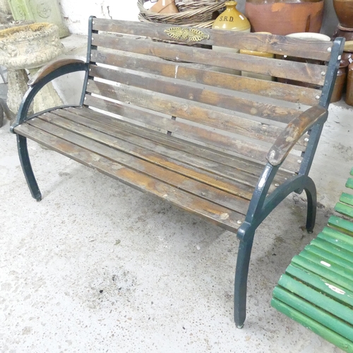 2680 - A teak slatted garden bench with cast iron ends. 132x82x62cm.