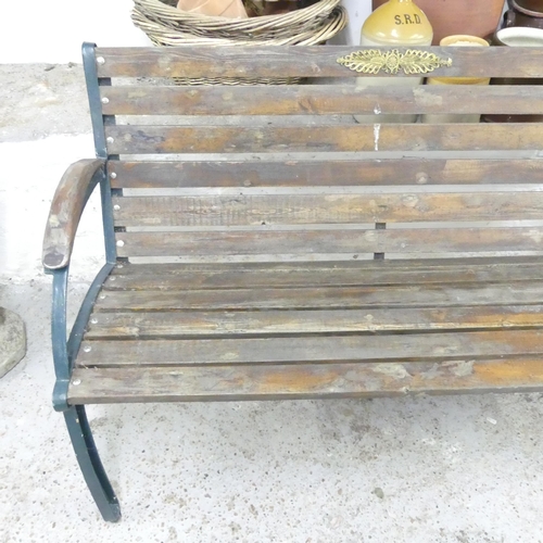 2680 - A teak slatted garden bench with cast iron ends. 132x82x62cm.