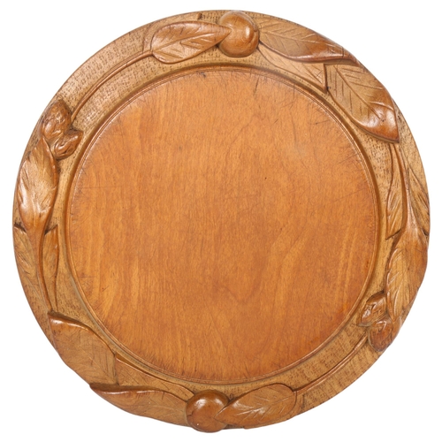 15 - A 20th century turned wood bread board, with applied leaf decoration, diameter 29cm