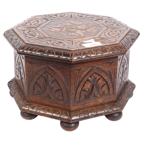 156 - A 1920s octagonal carved oak sewing box with hinged lid, diameter 31cm