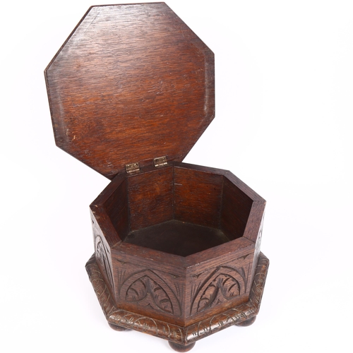 156 - A 1920s octagonal carved oak sewing box with hinged lid, diameter 31cm