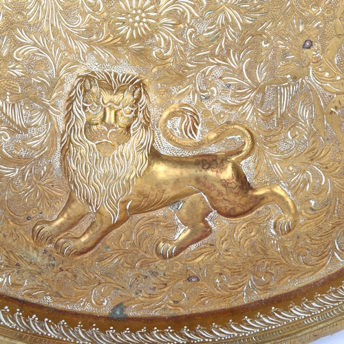 18 - An Indian brass circular tray, with repousse lions and engraved scrolled decoration, diameter 38.5cm