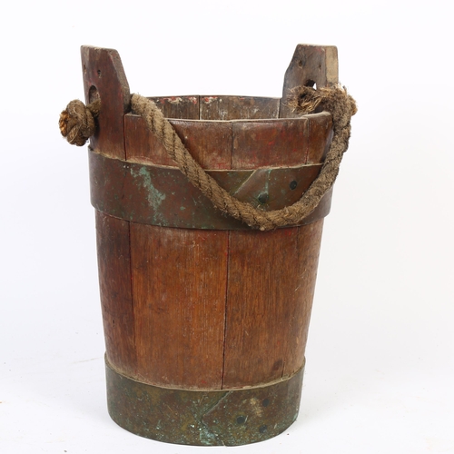 23 - A 19th century coopered oak fire bucket with rope handle, diameter 24cm, height 37.5cm