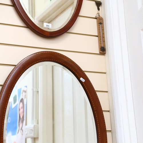 285 - 2 similar Vintage satinwood inlaid oval mirrors, with bevel-edged glass, largest 82cm x 56cm