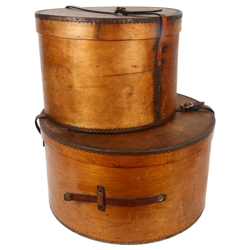 35 - A graduated pair of early 20th century bent ply hat boxes, with leather handles, largest diameter 45... 