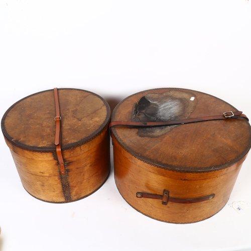 35 - A graduated pair of early 20th century bent ply hat boxes, with leather handles, largest diameter 45... 