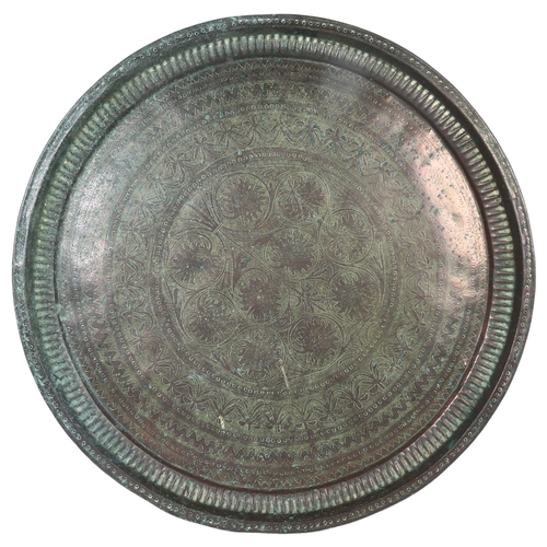 38 - A large Persian tin tray with engraved decoration, diameter 67.5cm
