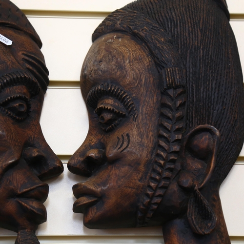 42 - A pair of African carved profile wall hangings, L60cm