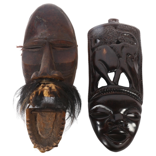 46 - A West African carved face mask, L36cm, and another (2)