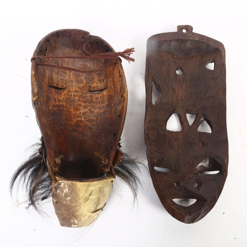 46 - A West African carved face mask, L36cm, and another (2)