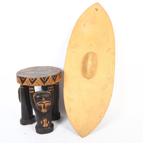 47 - A Ugandan carved stool, diameter 22cm, height 26.5cm, and an African shield, L66cm (2)
