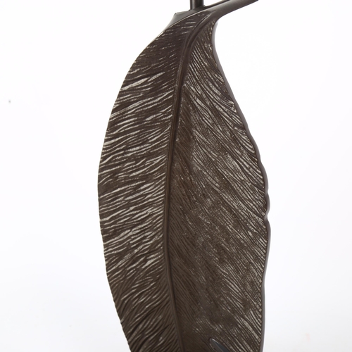 646 - A contemporary cast-metal lamp in the form of a feather, with LED bulb, and shade, H74cm