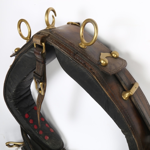 69 - An early 20th century leather and brass-mounted heavy horse collar, with straps