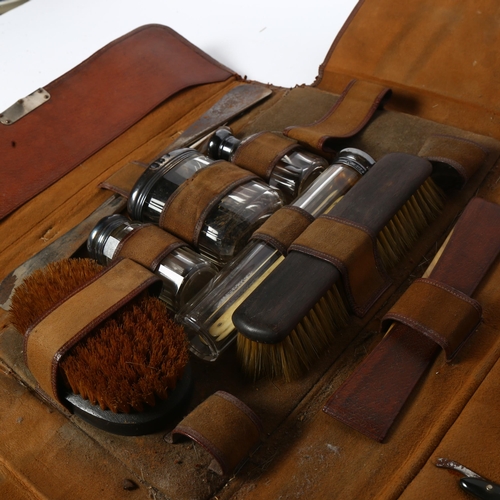 781 - A leather-cased gent's travelling set, including cut-throat razors, glass jars with silver tops, bru... 