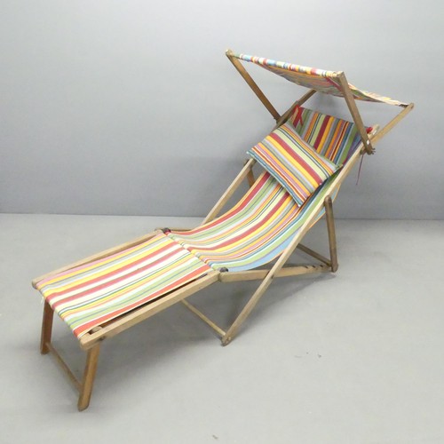 2599 - An early 20th century folding deck chair with canopy and attachable footrest.