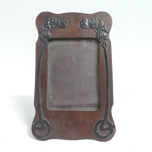 137 - An Art Nouveau embossed copper-mounted photo frame, and a 1920s oak photo frame with applied decorat... 