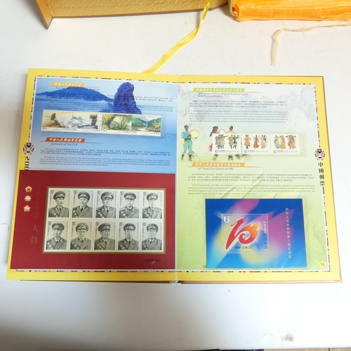 85 - An album of Chinese First Day Covers in presentation box, and an album of Chinese postage stamps