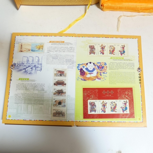 85 - An album of Chinese First Day Covers in presentation box, and an album of Chinese postage stamps