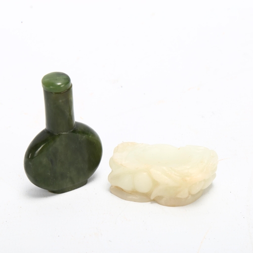 135 - A Chinese spinach jade snuff bottle and stopper, on carved white jade stand, height 8cm