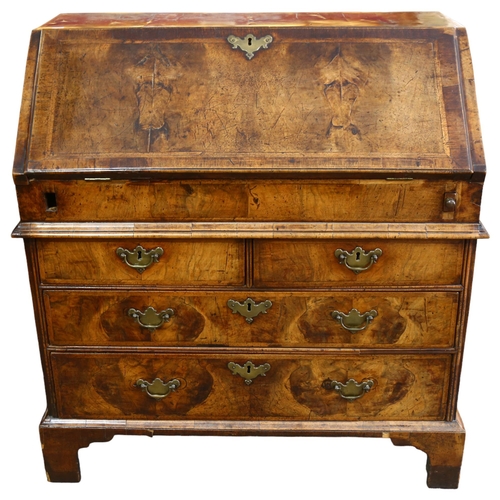 14 - An early 18th century walnut bureau, with stepped fitted interior, 2 short and 2 long drawers below ... 