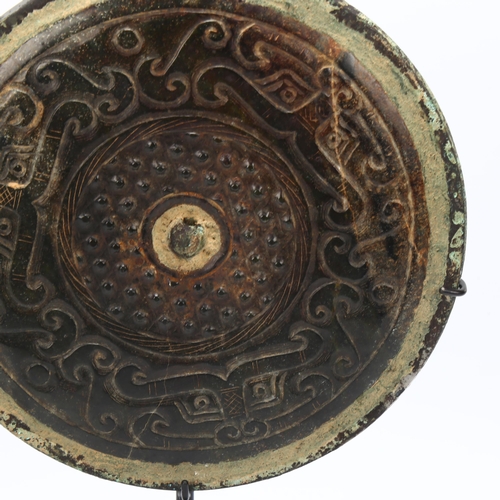 150 - A Chinese relief cast-bronze mirror, diameter 17.5cm, and a Chinese relief carved stone bi-disc, dia... 