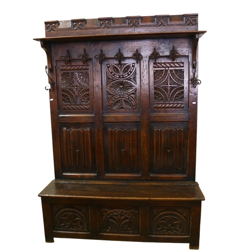 175 - A 19th century carved oak, linenfold, high-back settle/hall-stand, with shelf over hooks and box sea... 