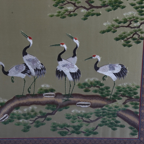 176 - A Chinese silk embroidered picture, depicting storks on a branch, machine embroidered surround, fram... 