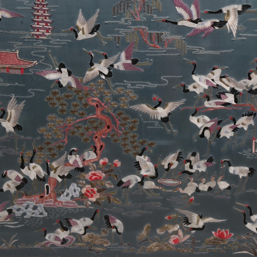 177 - A Chinese silk embroidered picture, depicting storks on a lake, machine embroidered surround, framed... 