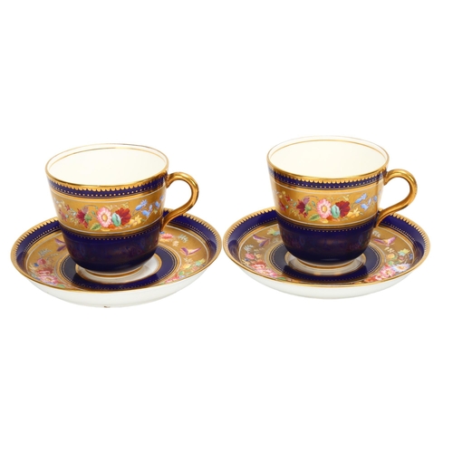 188 - A pair of 19th century blue and gilt porcelain cups and saucers, with hand painted bands of spring f... 