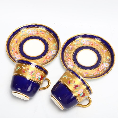 188 - A pair of 19th century blue and gilt porcelain cups and saucers, with hand painted bands of spring f... 