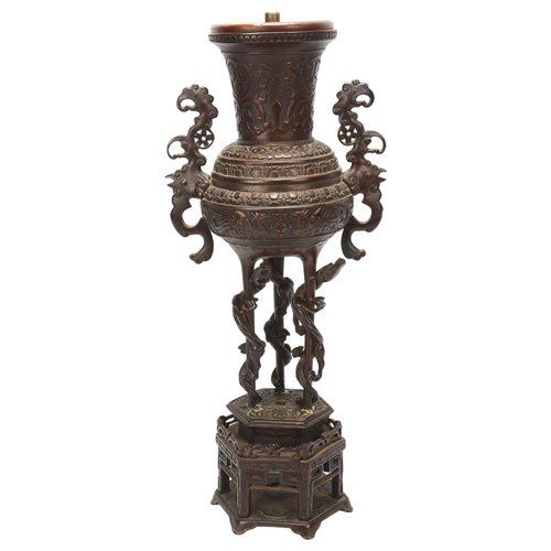 37 - A Chinese bronze incense burner converted to a lamp, with cast scrolled handles, raised on hexagonal... 