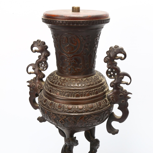 37 - A Chinese bronze incense burner converted to a lamp, with cast scrolled handles, raised on hexagonal... 