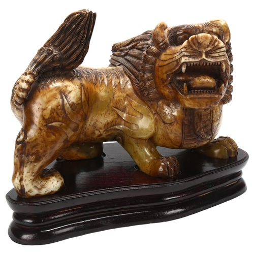 66 - A large early 20th century Chinese soapstone dog of fo, length approx 41cm, on wooden stand, in fitt... 