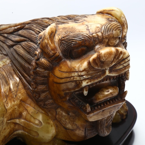 66 - A large early 20th century Chinese soapstone dog of fo, length approx 41cm, on wooden stand, in fitt... 