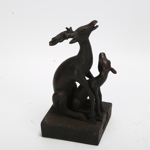 90 - A Chinese patinated bronze desk seal, in the form of 2 interlocking deer, height 11.5cm