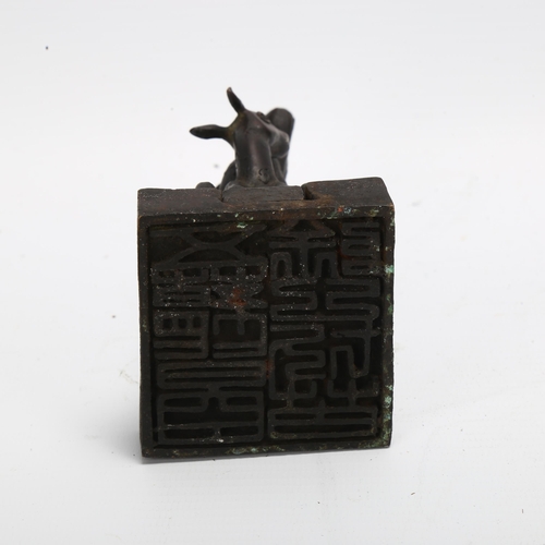 90 - A Chinese patinated bronze desk seal, in the form of 2 interlocking deer, height 11.5cm