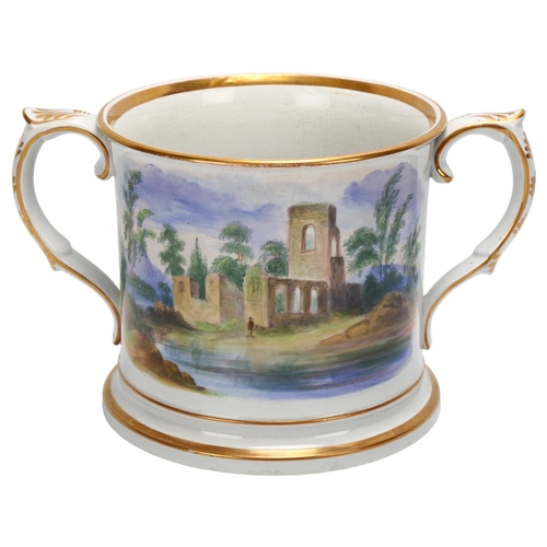 91 - A large 19th century English pottery 2-handled loving cup, with hand painted scene depicting church ... 